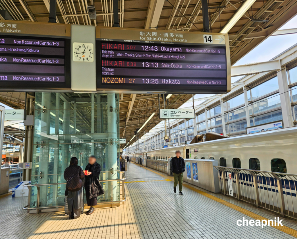Nozomi and Hikari shown in the Shinkansen timetable at the train platform