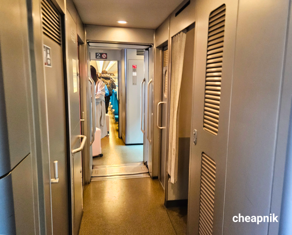 The deck area (the space between train cars) inside a Shinkansen that houses the doors, washrooms, sinks, and trash bins.